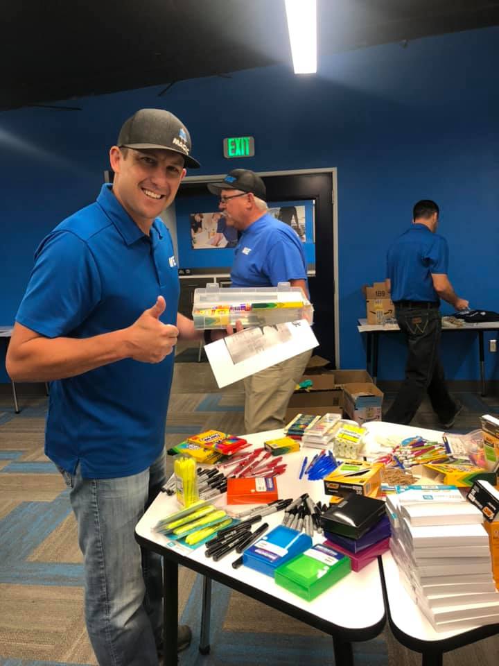 A member of the Magic Valley Electric LLC giving a thumbs up while gathering art supplies